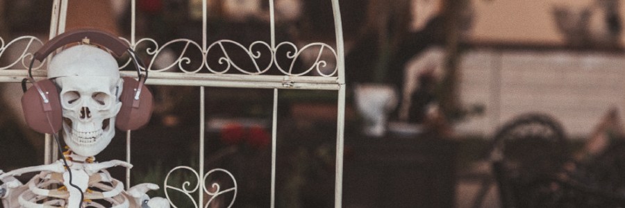 A seated skeleton wearing a large set of headphones